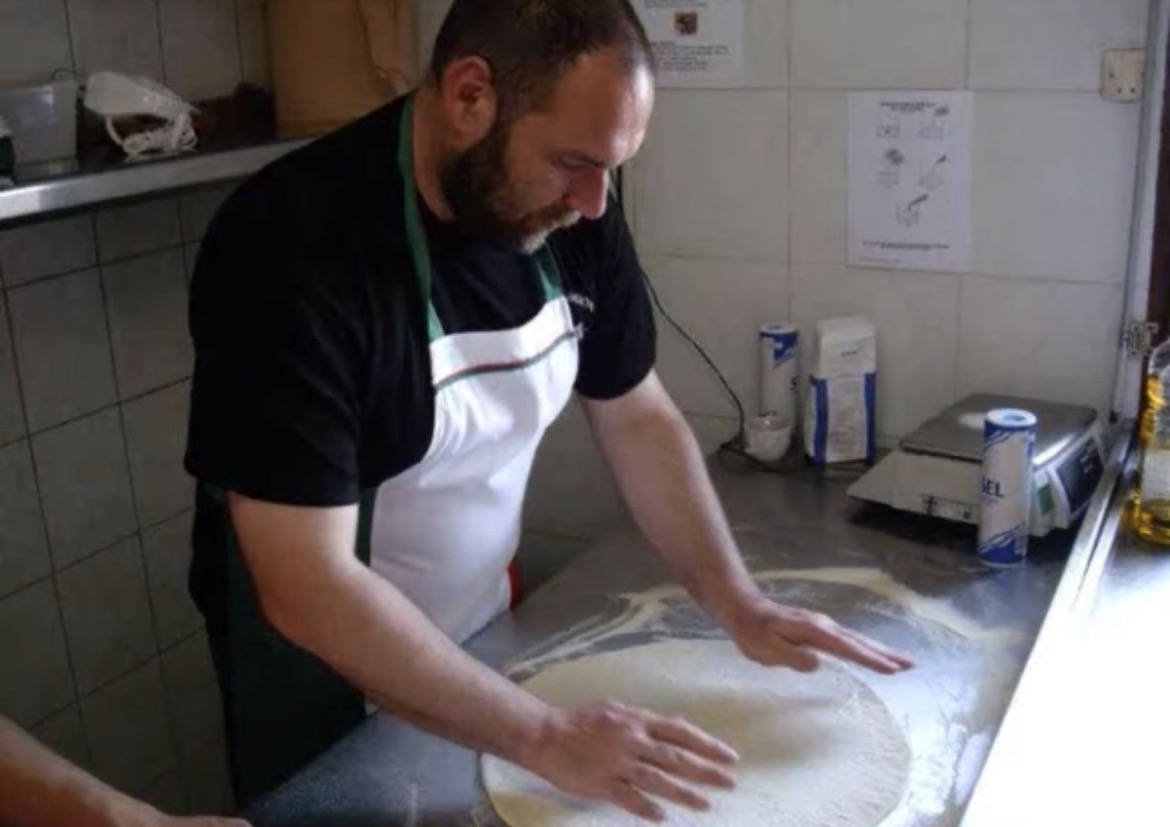 Travail manuel d'une pâte à pizza sur un plan fariné